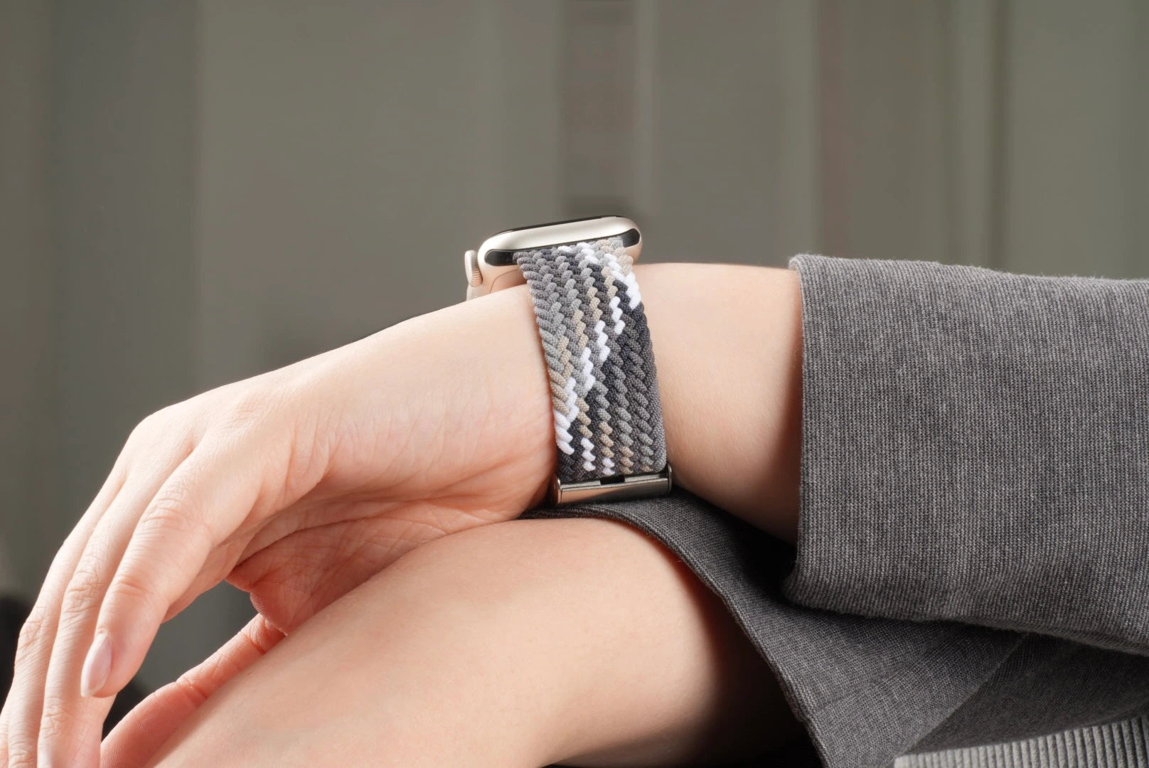 Apple Watch mit geflochtenem Nylonarmband in monochromen Grautönen am Handgelenk – stilvoll und bequem für den Alltag.