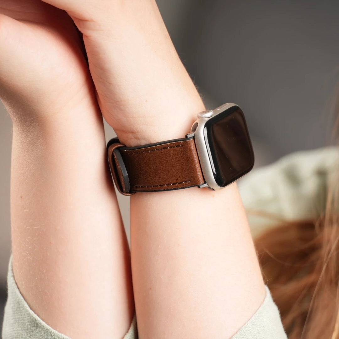 Nahaufnahme des Verschlusses des braunen Lederarmbands, das gerade angelegt wird. #farbe_braun
