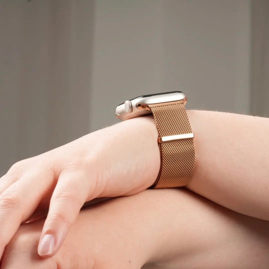 Apple Watch milanaise Armband am Handgelenk getragen von einer Frau in Roségold #farbe_Roségold