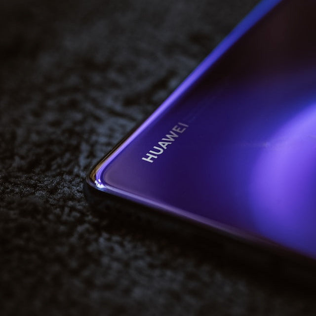 Rückseite eines Huawei Smartphones in lila Farbe, auf dunklem Hintergrund