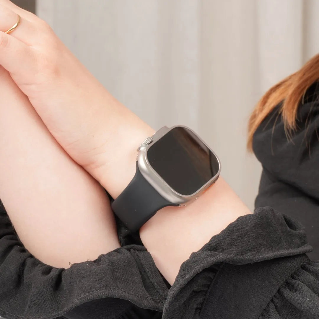 Apple Watch mit schwarzem Silikonarmband am Handgelenk #farbe_schwarz