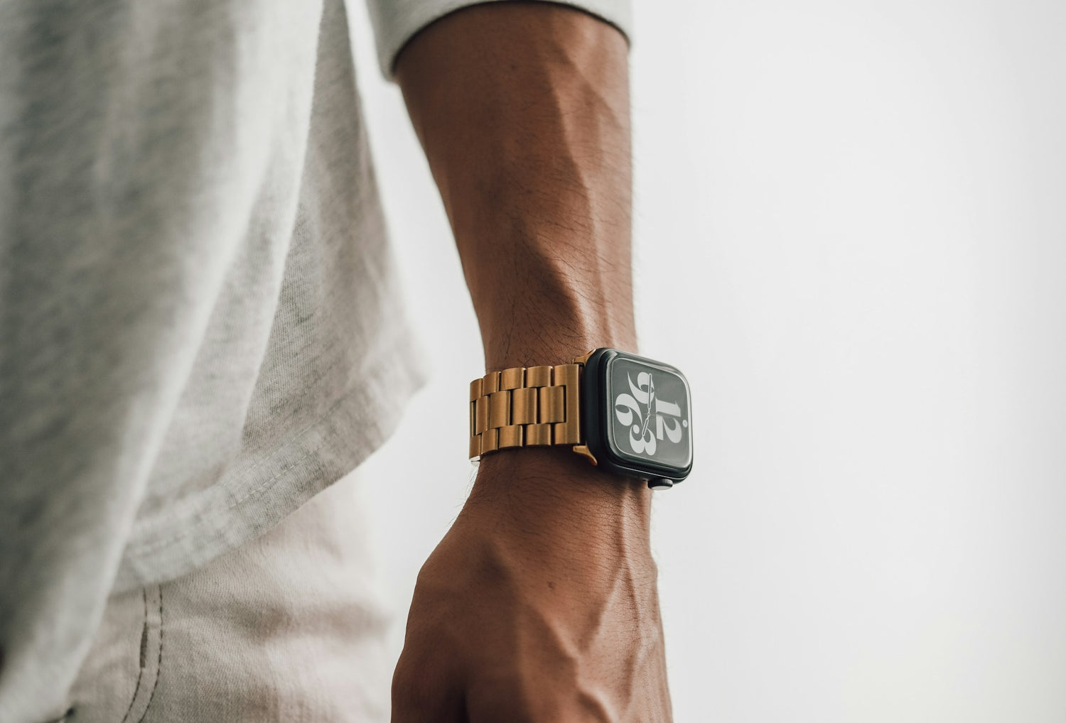 Apple Watch mit goldenem Metallarmband am Handgelenk einer Person